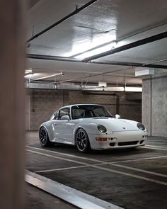 a white sports car parked in a parking garage