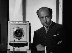 a man standing next to an old camera