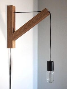 a light that is hanging from a wall next to a lamp on the wall with a cord