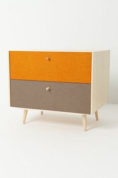 an orange and grey dresser sitting on top of a white floor