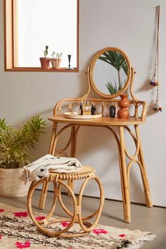 a small table with a mirror on top of it next to a potted plant