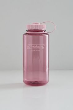 a pink water bottle sitting on top of a white table