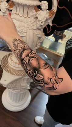 a woman's arm with an elephant and butterfly tattoo on the left side of her arm