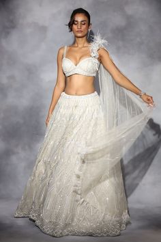 Ivory organza lehenga with silver pearls, sequins, crystals and cutdana hand embroidery. Comes with a blouse with an attached net draped.
Components: 2
Pattern: Hand embroidered
Type Of Work: Pearls, Sequins, Crystals, Cutdana
Neckline: Sweetheart
Sleeve Type: Sleeveless
Fabric: Organza, Drape : Net
Color: Ivory
Other Details: 
Lehenga length : 45 inches
Closure :
Lehenga : Drawstrings
Blouse : Side zip
Occasion: Destination Wedding - Aza Fashions Glamorous Organza Sets With Pearl Embroidery, Glamorous Wedding Lehenga With Pearl Embroidery, Glamorous Wedding Sets With Pearl Embroidery, Elegant Cream Choli For Party, Glamorous White Hand Embellished Sets, Glamorous White Fitted Lehenga, Elegant Cream Party Choli, Silver Embellished Organza Lehenga, Embellished Silver Organza Lehenga