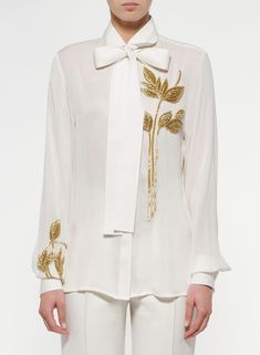 Elevate your elegance with our Women's White Classic Shirt, featuring intricate handwork and gold motifs. Perfect for weddings, bridesmaids, or formal dinner parties, this shirt is a timeless blend of sophistication and style. A thoughtful gift for her that adds a touch of glamour to any occasion. Make a statement in classic white with a touch of gold workshop now for refined grace!  Welcome to THE MAGNUS ATELIER on Etsy! We want to ensure your shopping experience is delightful and transparent. Please take a moment to review our shop policies before purchasing: 1. Processing Time: Each item is carefully crafted and made to order. Please check the individual product listing for the estimated processing time. For custom-made orders, the processing time may take up to 2-4 weeks, and for the r Luxury Designer Shirt For Festive Season, Luxury Elegant Patterned Shirt, Luxury Designer Festive Shirt, Luxury Festive Blouse With Intricate Embroidery, Luxury Designer Shirt For Women, Luxury Elegant Tops With Motifs, Luxury White Blouse With Resham Embroidery, Luxury Elegant Shirt With Embroidered Sleeves, Luxury Elegant Blouse With Embellishments