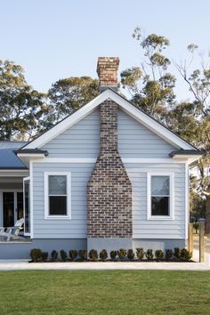 a house with a brick chimney in the front yard