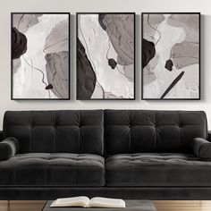 two black and white paintings hang above a couch