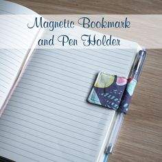 an open notebook and pen holder sitting on top of a wooden table with the title magnetic bookmark and pen holder