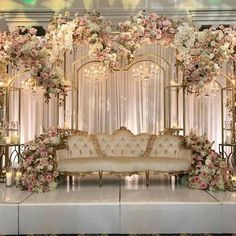 an elaborately decorated stage set up with flowers and candles for a wedding or reception