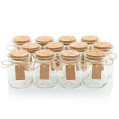 there are many empty glass jars with corks on the top and tags in each jar