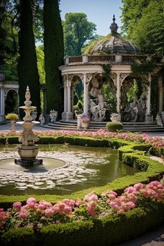 a fountain in the middle of a garden with pink flowers around it and an ornate gazebo behind it