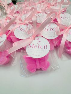 some pink teddy bears are wrapped in plastic and have tags that say, merci