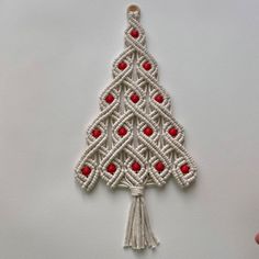 a white christmas tree ornament with red beads