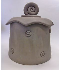 a gray ceramic container with a spiral design on the top