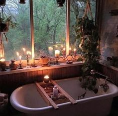 a bath tub sitting next to a window filled with candles