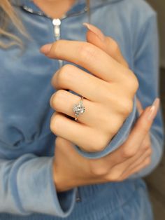 a woman wearing a diamond ring on her finger