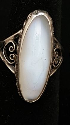 I really don't have a lot of information on this ring. It was acquired as one of many rings within an auction. I am unable to find anything like it anywhere. Description: The "stone" measures 25mm x 9mm, is an elongated oval, held in place by a simple retainer band. It appears to have held gases within at one time, or still does, as there are extremely small bubbles present. The bed of the ring is enclosed by a ring of minute beads supported by what appears to be a simulated twisted rope, encirc Vintage Oval Crystal Ring With Large Stone, Antique Oval Moonstone Ring Collectible, Vintage Adjustable Oval Moonstone Ring, Vintage White Oval Cabochon Ring, Vintage Oval Rings With Large Stone, Vintage Oval Cabochon Crystal Ring, Many Rings, Elongated Oval, Rings Statement