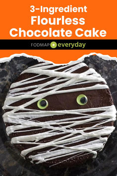 a chocolate cake with white icing and eyes on it, in front of an orange background