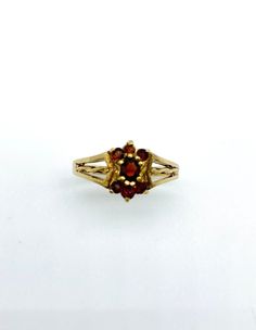 Description: Elegant beautifuly crafted Garnet Dress Ring. One central garnet surrounded by six smaller garnets and set in a beutifully made 9ct gold mount Metal: 9ct Yellow Gold Size: UK M1/2/ E.U 53/ U.S 6.5 Weight: 2.62gms Condition: Very Good Vintage Condition.  Notices: 1)Manufacture: Butterfly Rock VC is not the manufacturer. Items are sourced via a third party and as such we used the description of the item as it was presented to us. 2)Warranty: No warranty is given on this item. 3)Metal Finesse: If it is not otherwise stated then the quality/grade of the material is unknown. 4)Gemstones: Items containing gemstones are often treated to enhance colour or clarity. This has not been examined for this specific item.    5)Please see photos to assess the condition for yourself. We do not Gold Garnet Birthstone Ring, Victorian Yellow Gold Birthstone Ring With Gemstone, Vintage Yellow Gold Garnet Birthstone Ring, Victorian Yellow Gold Birthstone Ring, Vintage Garnet Birthstone Ring In Yellow Gold, Vintage Garnet Birthstone Rings, Victorian Style Yellow Gold Birthstone Ring, Vintage Oval Garnet Birthstone Ring, Formal Gold Garnet Birthstone Ring