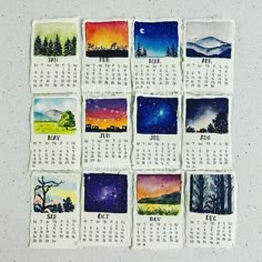 a calendar with pictures of the sky and trees on it, painted in watercolor