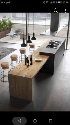 a modern kitchen with an island counter and stools in front of the stove top