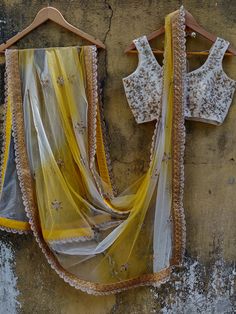 This ivory butti georgette lehenga is paired with an ivory embroidered raw silk blouse.  The outfit is complemented with a net yellow and ivory shaded dupatta with a scalloped border. Yellow Organza Choli With Intricate Embroidery, Yellow Organza Set With Intricate Embroidery, Yellow Organza Sets With Intricate Embroidery, Yellow Organza Sharara With Intricate Embroidery, Yellow Organza Lehenga With Intricate Embroidery, Yellow Anarkali Style Pre-draped Organza Saree, Yellow Elegant Lehenga With Sheer Dupatta, Elegant Yellow Lehenga With Sheer Dupatta, Yellow Georgette Dupatta With Intricate Embroidery