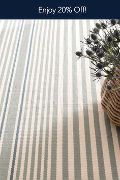 a basket filled with flowers sitting on top of a striped tablecloth covered in blue and white stripes