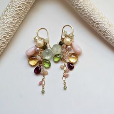 "Made to order. Production times for made to order items may be found in the shop announcement or the shop policies page. Soft pinks, shimmering golds, and sparkling greens drip down a luxurious chain. The first seven pictures are the earrings in rose gold filled, and the last three are in gold filled. ~ pink Peruvian opal, freshwater pearls, prehnite, rose quartz, Swarovski crystals, citrine, peridot, tourmaline, peach moonstone, rhodochrosite ~ rose gold filled, sterling silver, or gold filled Whimsical Teardrop Earrings For Pierced Ears, Whimsical Teardrop Jewelry For Pierced Ears, Gemstone Dangle Cluster Earrings As Gift, Whimsical Dangle Jewelry With Matching Earrings, Unique Long Drop Chandelier Earrings As Gift, Unique Long Drop Chandelier Earrings For Gifts, Briolette Natural Stones Earrings Gift, Briolette Natural Stone Earrings For Gift, Whimsical Sterling Silver Dangle Earrings