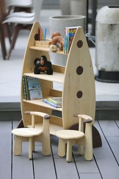 a wooden toy boat sitting on top of a table next to two children's chairs