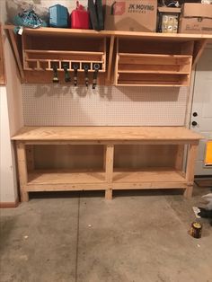 a workbench with lots of shelves and pegs on the wall next to it