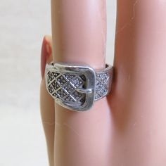 This handsome vintage sterling silver and rhinestone buckle style ring is a size 7. It has a real presence. The front of the ring measures 9/16ths inches inches high and tapers down to 1/4 inch in the back. It is a good solid ring and weighs in at 6.75 grams . The stones look like tiny diamonds but they are rhinestones. The ring is marked 925 for sterling and RJ. It is in very good condition with just a bit of wear to a few of the stones. We will send this to you in a lovely ring box for perfect Classic Adjustable Jewelry With Silver Buckle, Classic Silver Ring With Bling, Classic Silver Rings With Bling, Antique Silver Jewelry With Antique Buckle, Vintage Silver Open Diamond Ring, Buckle Ring, Rings Rings, Tiny Diamond, Sterling Jewelry