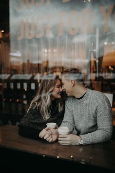 a man and woman sitting at a table in front of a window with the words just married written on it