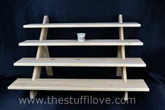 the shelf is made from wood and has three shelves on each side, one with a cup in it