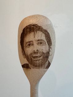 a wooden spoon with a drawing of a man on it