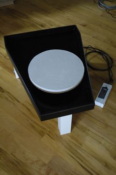 an electronic device sitting on top of a black and white table next to a charger