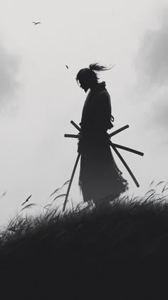 the silhouette of a person holding two large sticks in front of their head and standing on top of a grass covered hill