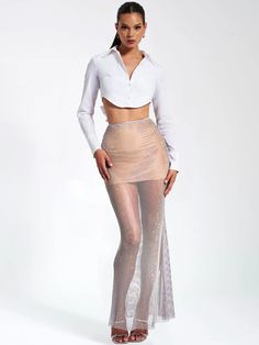 Illuminate the night with the Gloria Mesh Rhinestone Maxi Skirt. This enchanting grey masterpiece boasts a netted rhinestone design and a silver satin waistband for a touch of elegance. Crafted from stretch diamond netted fabric, it features a nude mesh mini skirt lining for comfort. The invisible zipper at the center back ensures a seamless fit. Perfect for any special occasion. Also available in similar styles with the same rhinestone fabric. See our black maxi dress version, Quiana Mesh Rhine Mesh Mini Skirt, Rhinestone Fabric, Skirt Lining, Shirt Crop Top, Tie Dye Jumpsuit, White Long Sleeve Shirt, Maxi Dress Cocktail, Mesh Skirt, Black Maxi