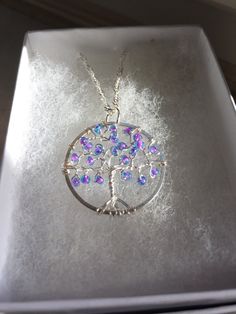 This is a handmade pendant about the size of a quarter.  It is made with the best materials I can find:  -silver plated wire -silver plated hoop -glass beads And also comes with an 18in silver plated chain. This makes a great gift for any special lady that you may have in your life, a best friend, or just something to spoil yourself with!  Please contact me if you have any further questions! Silver Crystal Pendant Necklace For Gift, Iridescent Sterling Silver Round Pendant Necklace, Wire Wrapped Crystal Necklace With Round Pendant For Gift, Iridescent Sterling Silver Necklace With Round Pendant, Crystal Necklace With Large Round Pendant For Gift, Gift Crystal Necklace With Large Round Pendant, Silver Round Crystal Necklace For Gift, Silver Tree Of Life Round Pendant Necklace, Iridescent Metal Necklace Gift