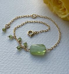 Stylish bracelet made of a huge faceted apple green Peridot gemstone, smaller Peridot beads and delicate but sturdy 14k Gold Filled cable chain.  Size of the large Peridot gemstone is approximately 1,4 x 0,8 cm. It is a totally natural gemstone which has been only roughly faceted so it is asymmetric and has some natural roughness. There are 4 small faceted Peridot beads attached to one side of the bracelet and one to the other end.  Total length of the bracelet is about 8.3" (21 cm) and there is Faceted Beads Bracelets As May Birthstone Gift, Faceted Beads Bracelet For May Birthstone Gift, Green Faceted Beads Jewelry As Gift, May Birthstone Faceted Beads Bracelet, Green Faceted Beads Jewelry For Gift, May Birthstone Bracelets With Faceted Beads As Gift, Peridot Faceted Jewelry For May Birthstone, Faceted Peridot Jewelry For May Birthstone, Green Beaded Stone Bracelets As Gift