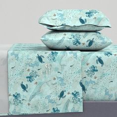 three pillows and two pillow cases are stacked on top of each other with an octopus print