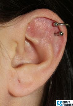 a close up of a person's ear with two piercings