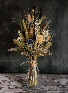 a vase filled with lots of different types of flowers