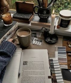 an open book sitting on top of a table next to a cup of coffee