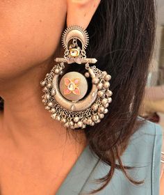 Statement silver boho ghungroo Kundan chandbaali earrings for a stunning look. Perfect for adding a unique and stylish touch to any outfit. Earring Dimensions:  Approximately 3.2 Inches Long  Approximately 2 Inches Wide  A Earring Weight is 1.3 oz All our products are crafted using traditional skills from our rich heritage. The manual nature of these crafts means that irregularities or variations are inherent in the handcrafting process. Festive Silver Chandelier Earrings With Tilla, Bohemian Kundan Dangle Danglers, Silver Chandbali Fusion Chandelier Earrings, Bohemian Kundan Dangle Earrings, Festive Fusion Style Dangle Danglers, Festive Fusion Dangle Danglers, Diwali Fusion Style Dangle Danglers, Metal Fusion Style Chandbalis For Festivals, Fusion Style Danglers For Diwali