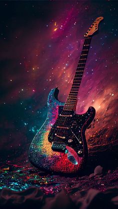 an electric guitar sitting on top of a floor covered in colorful paint and glitters