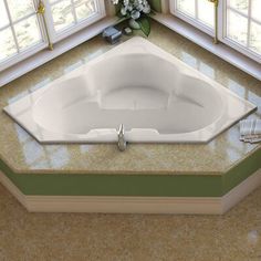 a large white bath tub sitting in the middle of a room next to two windows