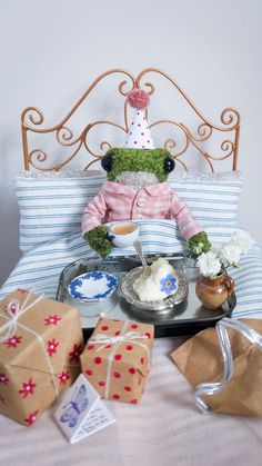 a teddy bear sitting on top of a bed next to presents