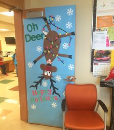 a classroom door decorated with an image of a reindeer hanging from the tree and snowflakes