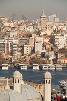 there are many boats on the water in this cityscape that is full of tall buildings