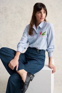 In a new shape for Blue Illusion, the Cotton Seersucker Shirt is a fun take on the classic striped shirt. Featuring a large pink tulip embroidered motif as well as contrast pink embroidery detailing, this shirt is crafted from ultra-comfortable cotton seersucker and will make any outfit pop. Spring Floral Embroidery Relaxed Fit Shirt, Spring Button-up Shirt With Striped Collar, Spring Striped Collar Button-up Shirt, Embroidered Relaxed Fit Shirt For Spring, Pinstripe Cotton Blouse With Striped Collar, Summer Long Sleeve Shirt With Striped Cuffs, Cotton Pinstripe Blouse With Striped Collar, Spring Long Sleeve Shirt With Striped Collar, Casual Floral Embroidered Shirt For Spring